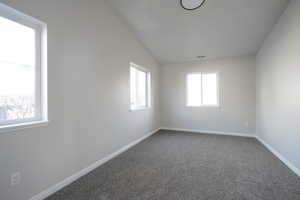 Spare room with carpet floors and lofted ceiling