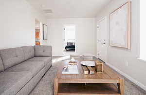 Carpeted living area with baseboards