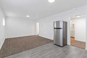 Empty room featuring baseboards and light carpet