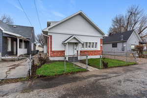 Bungalow with brick siding, a gate, and a fenced front yard