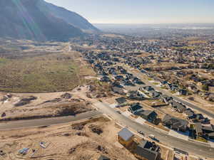 Aerial view of property and surrounding area featuring mountains and nearby suburban area