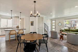 Dining room featuring a chandelier, stairway, dark wood finished floors, recessed lighting, and a textured ceiling