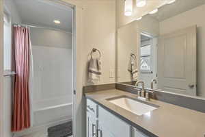 Bathroom featuring vanity, shower / bath combo, and recessed lighting