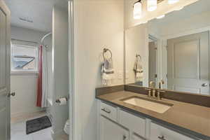 Full bath with vanity, light marble finish floors, and shower / bath combo