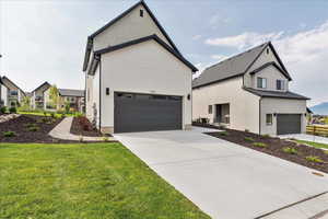 Modern farmhouse with a garage, driveway, and a front lawn