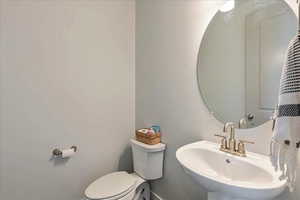 Half bathroom with toilet and a sink