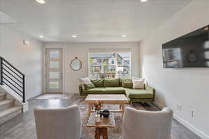 Living room featuring hardwood / wood-style flooring, stairs, a textured ceiling, and recessed lighting