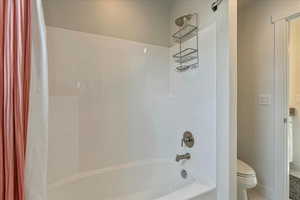 Bathroom featuring shower / bath combo and toilet