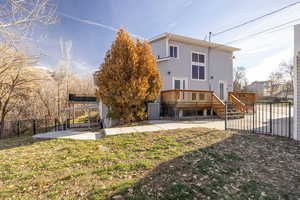 Rear view of property featuring a fenced backyard, a wooden deck, a patio, and a gate