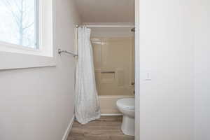 Upstairs ensuite bathroom with shower / tub combo and light wood-type flooring