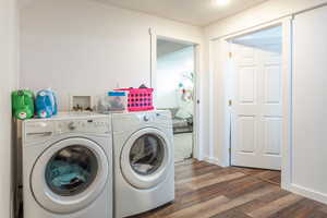 Laundry room featuring dark wood-style floors and washing machine and dryer