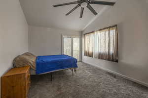 Main floor ensuite Bedroom with lofted ceiling, carpet, a ceiling fan, access to outside, and ensuite bathroom and private deck,