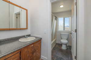Upstairs Full Bathroom featuring stone tile flooring, vanity, and shower / bath combo with shower curtain