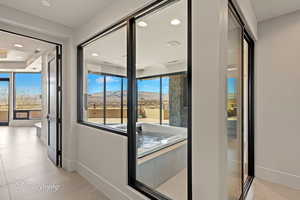 Hallway with a mountain view, recessed lighting, and light tile patterned floors