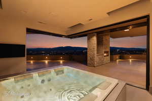 View of swimming pool with a patio area, an outdoor hot tub, and a mountain view