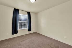 Carpeted spare room with baseboards