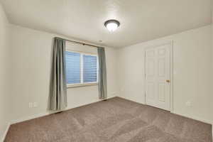 Spare room with a textured ceiling and carpet
