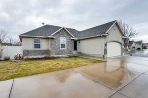 Ranch-style home featuring stone siding, stucco siding, concrete driveway, a shingled roof, and a garage