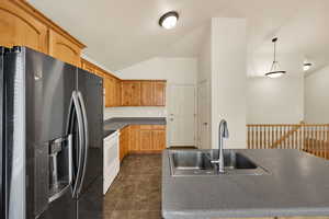 Kitchen featuring stainless steel fridge with ice dispenser, white range with electric stovetop, hanging light fixtures, lofted ceiling, and dark countertops