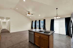 Kitchen featuring brown cabinetry, open floor plan, pendant lighting, dark carpet, and lofted ceiling