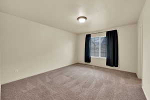 Unfurnished room with carpet flooring and a textured ceiling