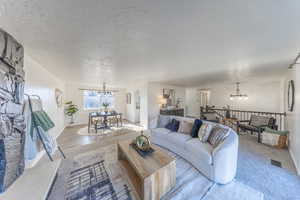 Living room featuring a chandelier and a textured ceiling