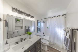 Bathroom featuring shower / bath combination with curtain, vanity, and light wood-style floors