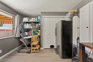 Office space featuring light wood-type flooring and a textured ceiling