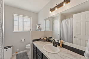 Bathroom featuring a shower with shower curtain and vanity