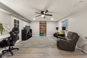Living area with an office area, ceiling fan, light wood finished floors, and recessed lighting