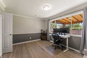 Office space with light wood finished floors and ornamental molding