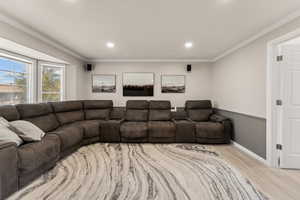 Living area featuring crown molding, light wood finished floors, and recessed lighting