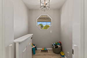 Washroom with light wood-style floors and a chandelier