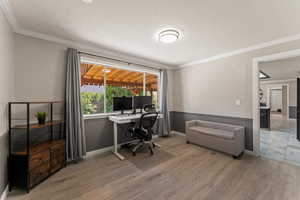 Office with light wood finished floors and ornamental molding