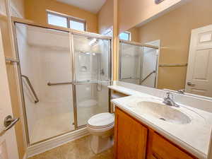 Full bathroom with vanity and a shower stall with grab bars