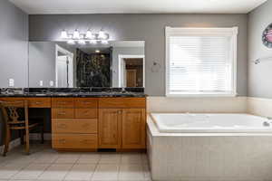 Full bath with double vanity, a shower stall, a bath, and light tile patterned flooring
