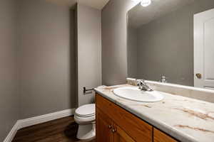 Half bath featuring vanity and dark wood-style floors