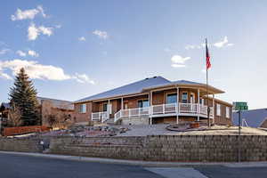 View of front of property featuring covered porch and brick siding