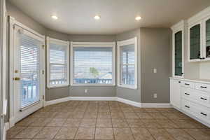 Unfurnished dining area featuring light tile patterned floors and recessed lighting
