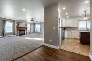 Unfurnished living room with recessed lighting, a fireplace, light wood-style floors, a textured ceiling, and a ceiling fan