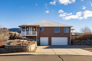 View of front facade with a garage, brick siding, driveway, a mountain view, and a shingled roof