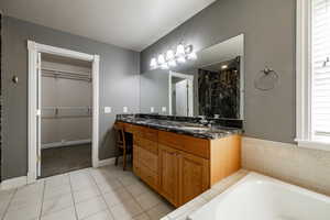 Full bath with a bath, double vanity, a shower stall, and plenty of natural light