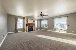 Unfurnished living room featuring a fireplace with flush hearth, a ceiling fan, carpet flooring, and recessed lighting