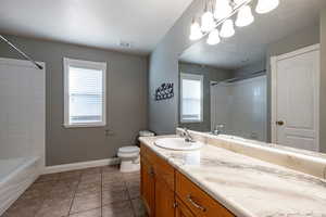 Bathroom with vanity, light tile patterned floors, healthy amount of natural light, and bathing tub / shower combination