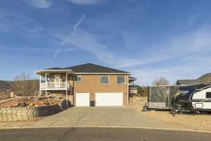 View of front of home with an attached garage, brick siding, and driveway