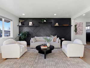 Living room featuring an accent wall, wood finished floors, and recessed lighting