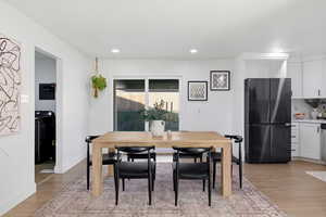 Dining room with light wood-type flooring and recessed lighting