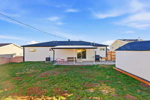 Rear view of property with a fenced backyard, a patio area, and an outbuilding