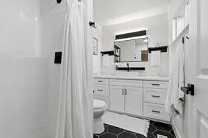 En-Suite bathroom with vanity, a shower, and dark tile patterned floors
