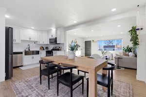Dining space with light wood-type flooring and recessed lighting